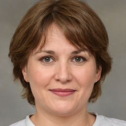 Joyful white adult female with medium  brown hair and grey eyes