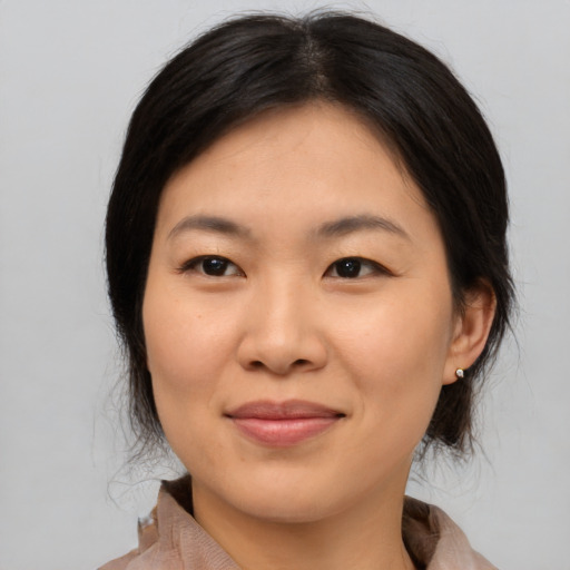 Joyful asian young-adult female with medium  brown hair and brown eyes