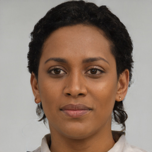 Joyful black young-adult female with short  brown hair and brown eyes