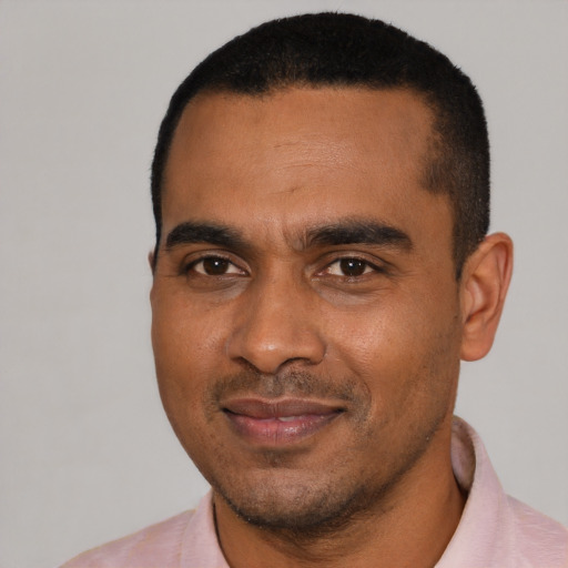Joyful black young-adult male with short  black hair and brown eyes