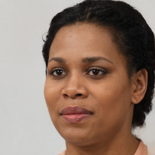 Joyful black young-adult female with short  black hair and brown eyes