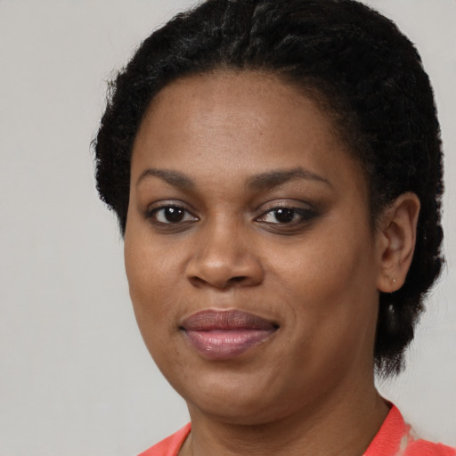 Joyful black adult female with short  black hair and brown eyes