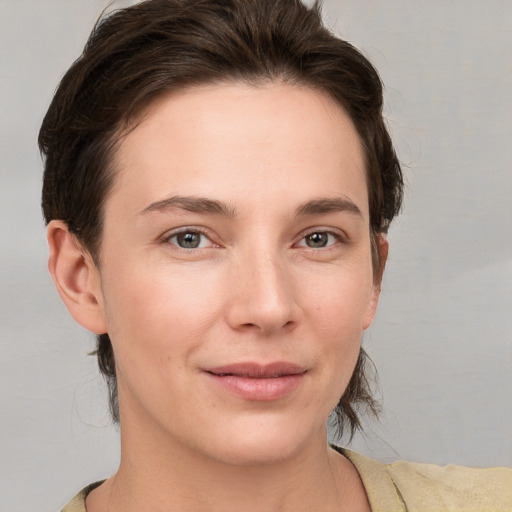 Joyful white young-adult female with short  brown hair and grey eyes