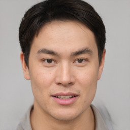 Joyful asian young-adult male with short  brown hair and brown eyes