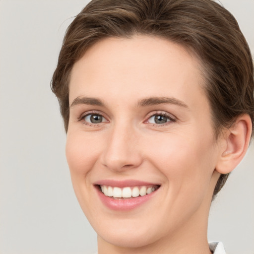 Joyful white young-adult female with medium  brown hair and green eyes