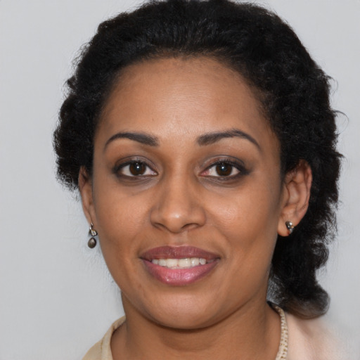 Joyful black adult female with long  brown hair and brown eyes