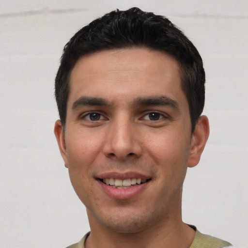 Joyful white young-adult male with short  black hair and brown eyes