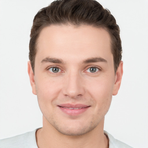 Joyful white young-adult male with short  brown hair and grey eyes