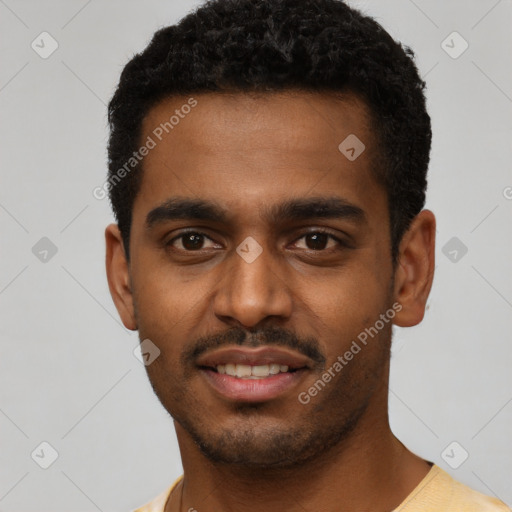 Joyful black young-adult male with short  black hair and brown eyes