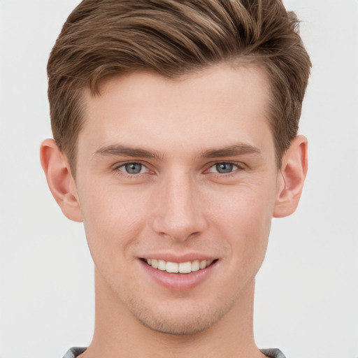 Joyful white young-adult male with short  brown hair and grey eyes