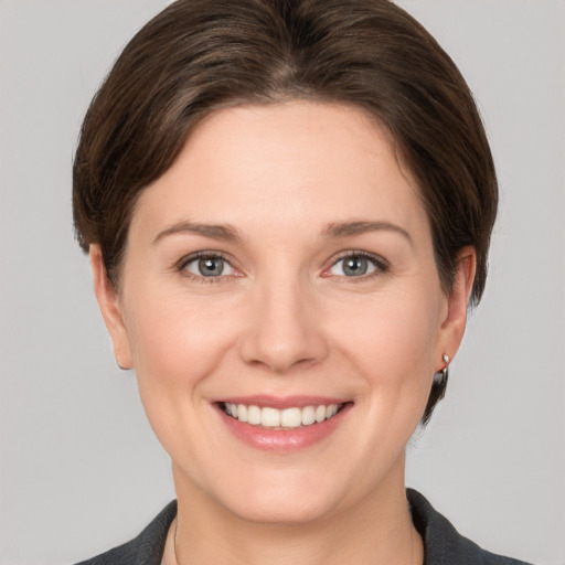 Joyful white young-adult female with medium  brown hair and grey eyes