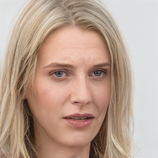 Joyful white young-adult female with long  blond hair and blue eyes