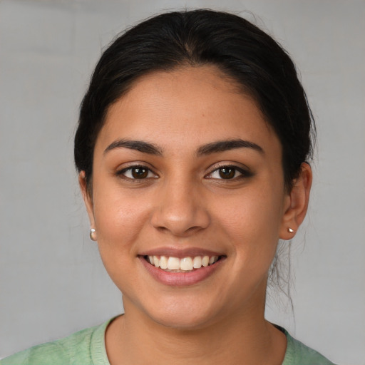 Joyful latino young-adult female with medium  brown hair and brown eyes