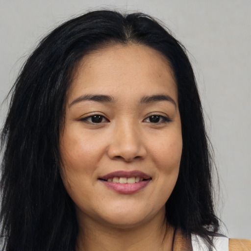 Joyful asian young-adult female with long  brown hair and brown eyes