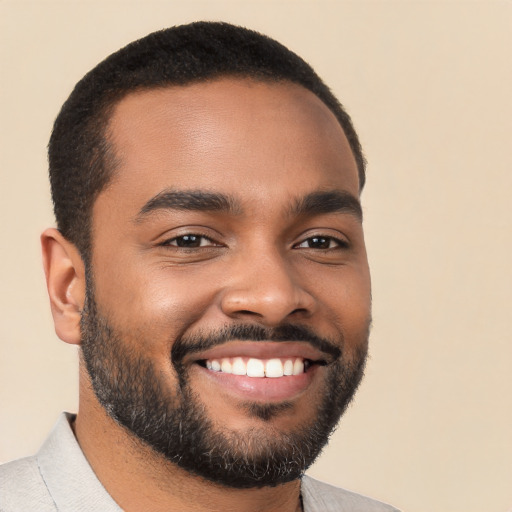 Joyful black young-adult male with short  black hair and brown eyes