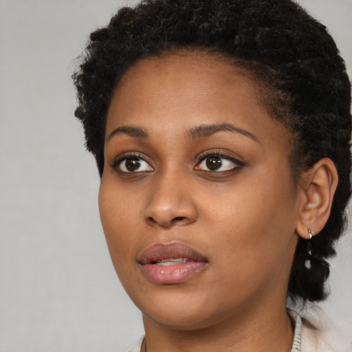 Joyful black young-adult female with short  brown hair and brown eyes
