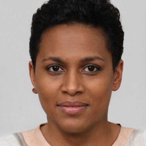 Joyful black young-adult female with short  black hair and brown eyes