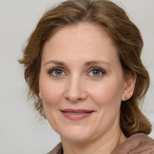 Joyful white adult female with medium  brown hair and grey eyes