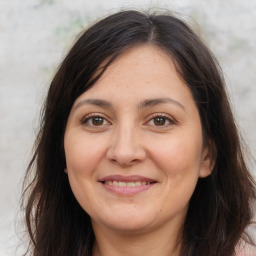 Joyful white adult female with long  brown hair and brown eyes