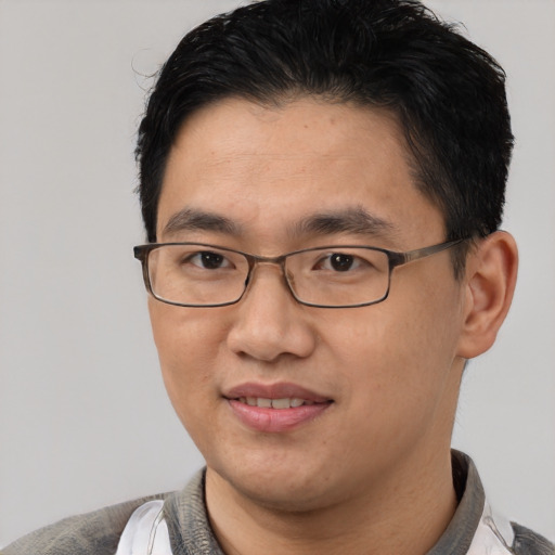 Joyful asian young-adult male with short  black hair and brown eyes