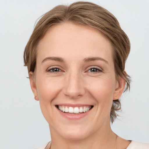 Joyful white young-adult female with medium  brown hair and grey eyes