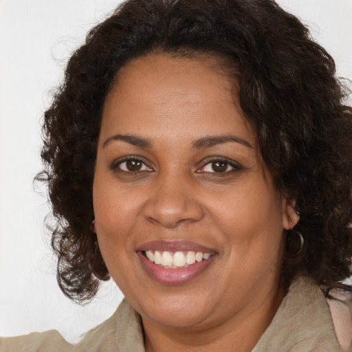 Joyful black adult female with long  brown hair and brown eyes