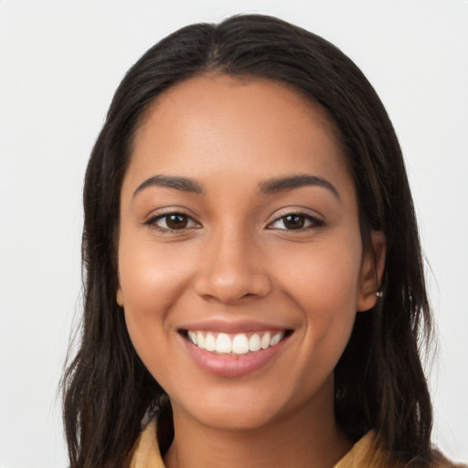 Joyful latino young-adult female with long  brown hair and brown eyes