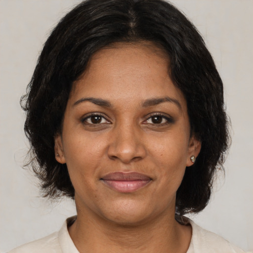 Joyful black young-adult female with medium  brown hair and brown eyes