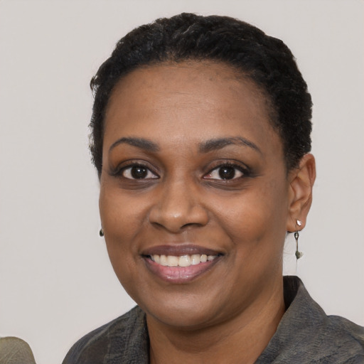 Joyful black young-adult female with short  black hair and brown eyes