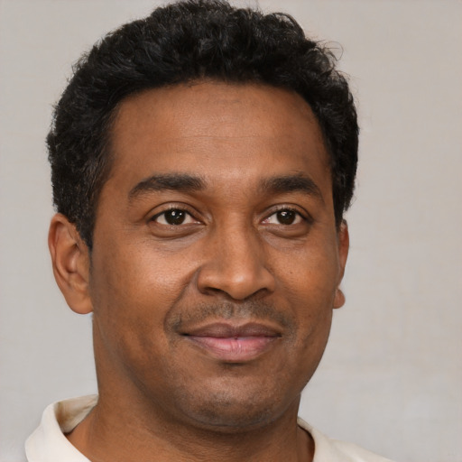 Joyful black young-adult male with short  brown hair and brown eyes