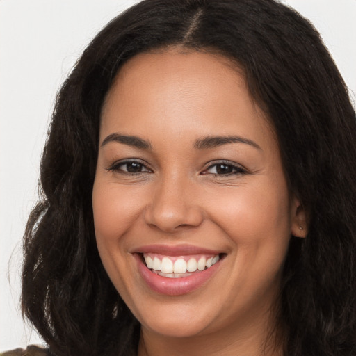 Joyful latino young-adult female with long  brown hair and brown eyes