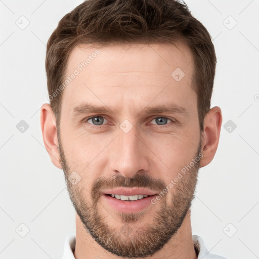 Joyful white young-adult male with short  brown hair and grey eyes