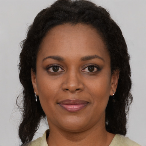 Joyful black young-adult female with medium  brown hair and brown eyes