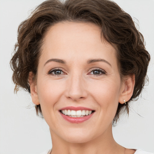 Joyful white adult female with medium  brown hair and green eyes