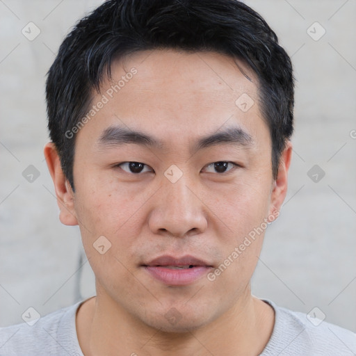 Joyful asian young-adult male with short  black hair and brown eyes