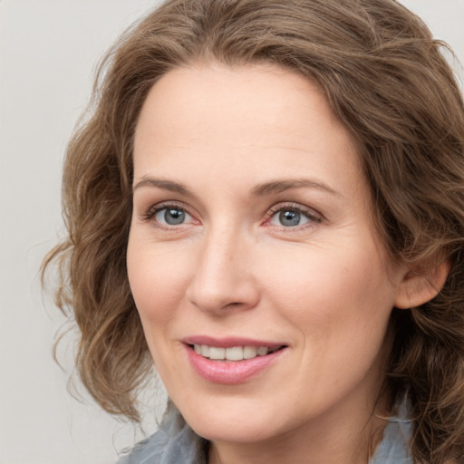 Joyful white young-adult female with medium  brown hair and blue eyes