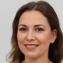 Joyful white adult female with long  brown hair and brown eyes