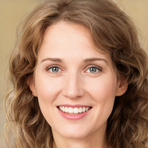 Joyful white young-adult female with long  brown hair and green eyes