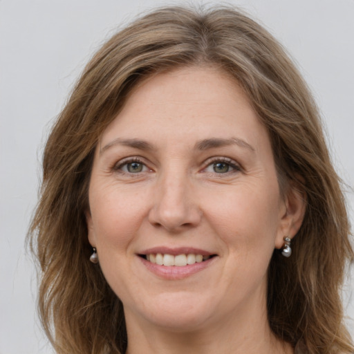 Joyful white adult female with long  brown hair and grey eyes