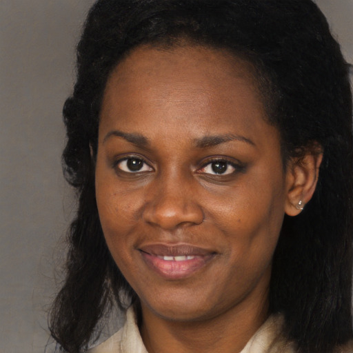 Joyful black young-adult female with long  brown hair and brown eyes