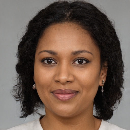 Joyful black young-adult female with medium  brown hair and brown eyes