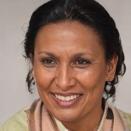 Joyful latino adult female with medium  brown hair and brown eyes