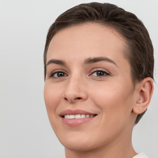 Joyful white young-adult female with short  brown hair and brown eyes