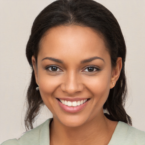 Joyful latino young-adult female with medium  brown hair and brown eyes