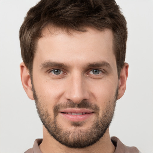 Joyful white young-adult male with short  brown hair and grey eyes