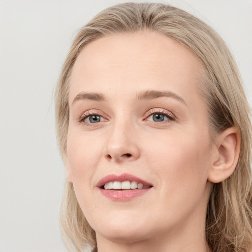 Joyful white young-adult female with long  brown hair and blue eyes