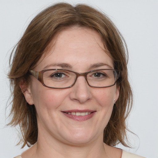 Joyful white adult female with medium  brown hair and blue eyes