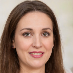 Joyful white young-adult female with long  brown hair and green eyes