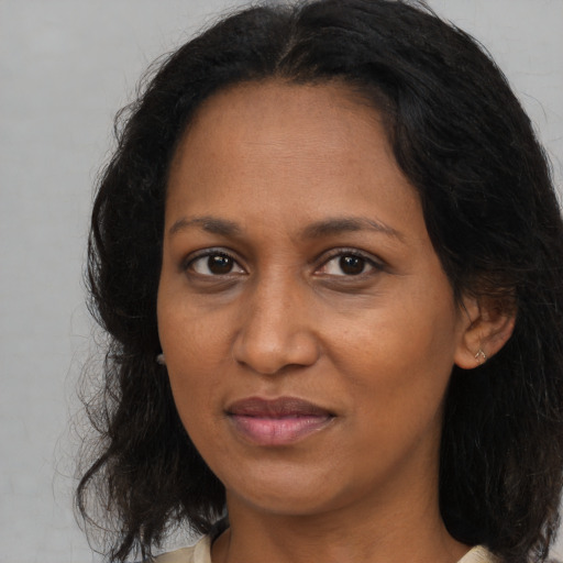 Joyful black adult female with medium  brown hair and brown eyes