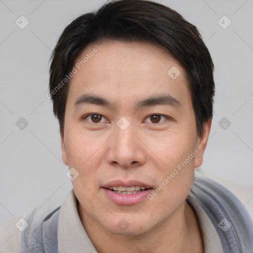 Joyful asian young-adult male with short  brown hair and brown eyes